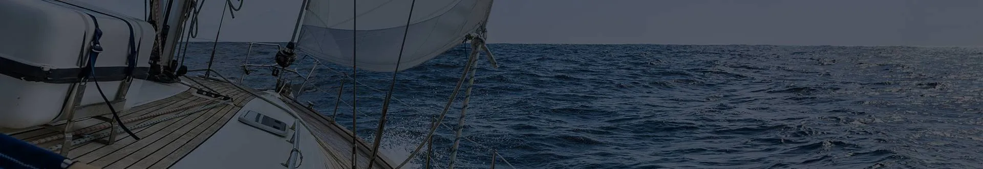 Sailboat deck and sail heading out across open water