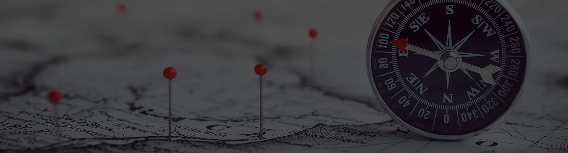 Compass on a map marked with red pins